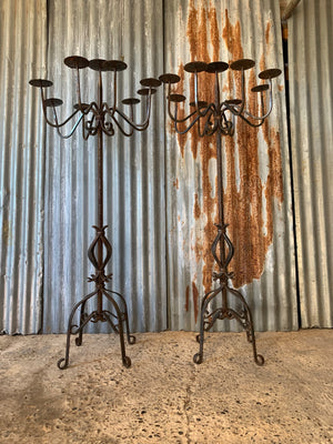 A Victorian pair of black cast iron floor standing church candelabra