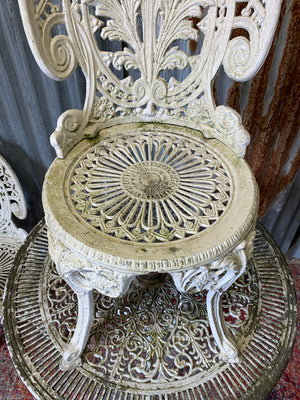 A white cast metal garden table and two chairs