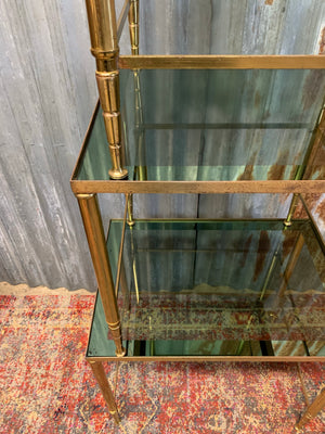 A brass and glass Hollywood Regency nest of three tables