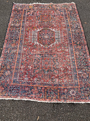 A large rectangular red ground Persian rug
