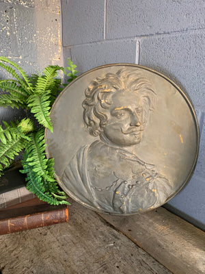 A metal roundel relief plaque of a gentleman