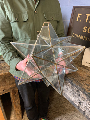 A glass and brass star ceiling light