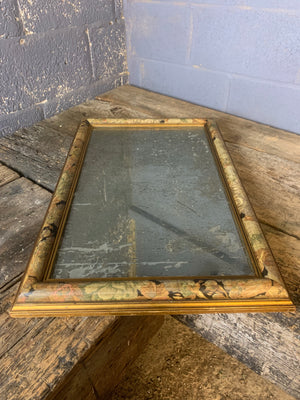A heavily foxed mercury mirror with floral frame