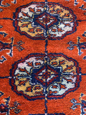 A Persian orange-red ground rectangular rug with multiple lozenge