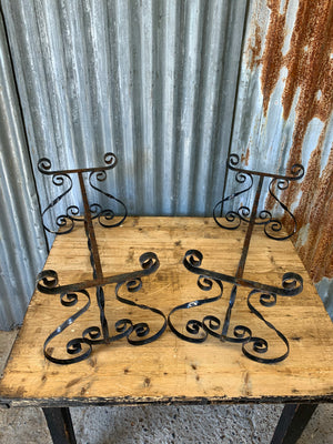 A weathered black wrought iron plant stand