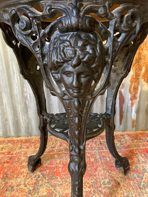 A cast iron Britannia garden table with oak top