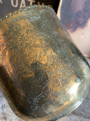 An ornately carved brass planter