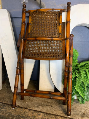 A faux bamboo carved hardwood folding campaign chair