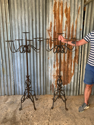 A Victorian pair of black cast iron floor standing church candelabra