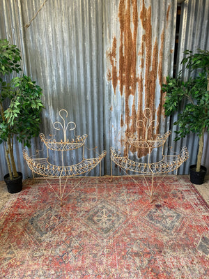 A pair of white wirework demi-lune plant stands