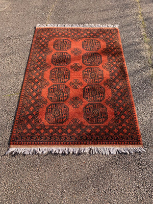 A burnt orange ground Bokhara rectangular rug- 195cm x 124cm