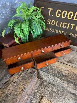 A bank of wooden table top drawers