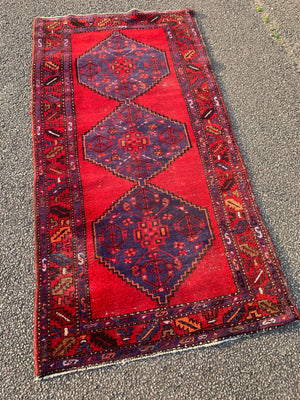 A red ground runner rug - 207cm x 108cm