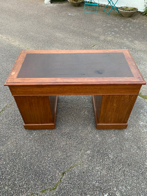A small wooden pedestal desk