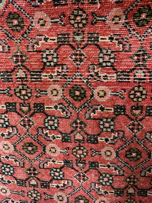 A long pink and red ground Persian Hosseinabad runner rug