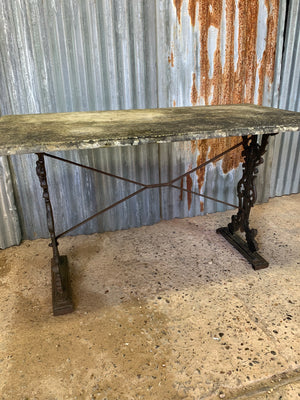 A cast iron garden table with marble top