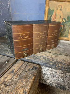 A set of three brown leather and brass book boxes