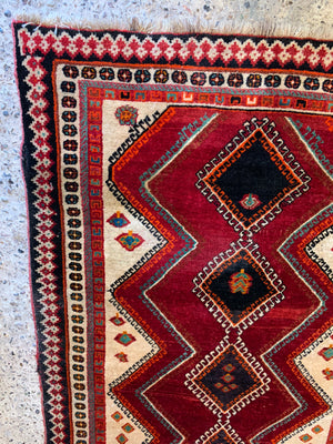 A hand woven Persian red ground rectangular rug