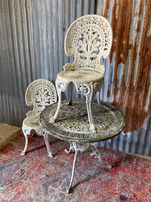 A white cast metal garden table and two chairs