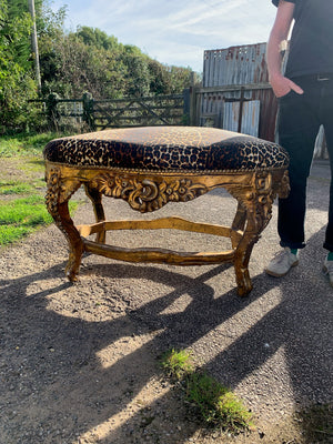 A large rococo style leopard and giltwood bench seat