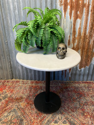A cast iron table with circular marble top