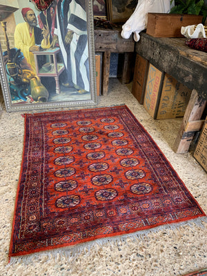 A Persian orange-red ground rectangular rug with multiple lozenge