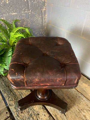 A red leather and mahogany stool