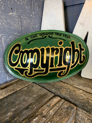 A convex 'Copyright: A Cut Above The Rest' trade advertising sign