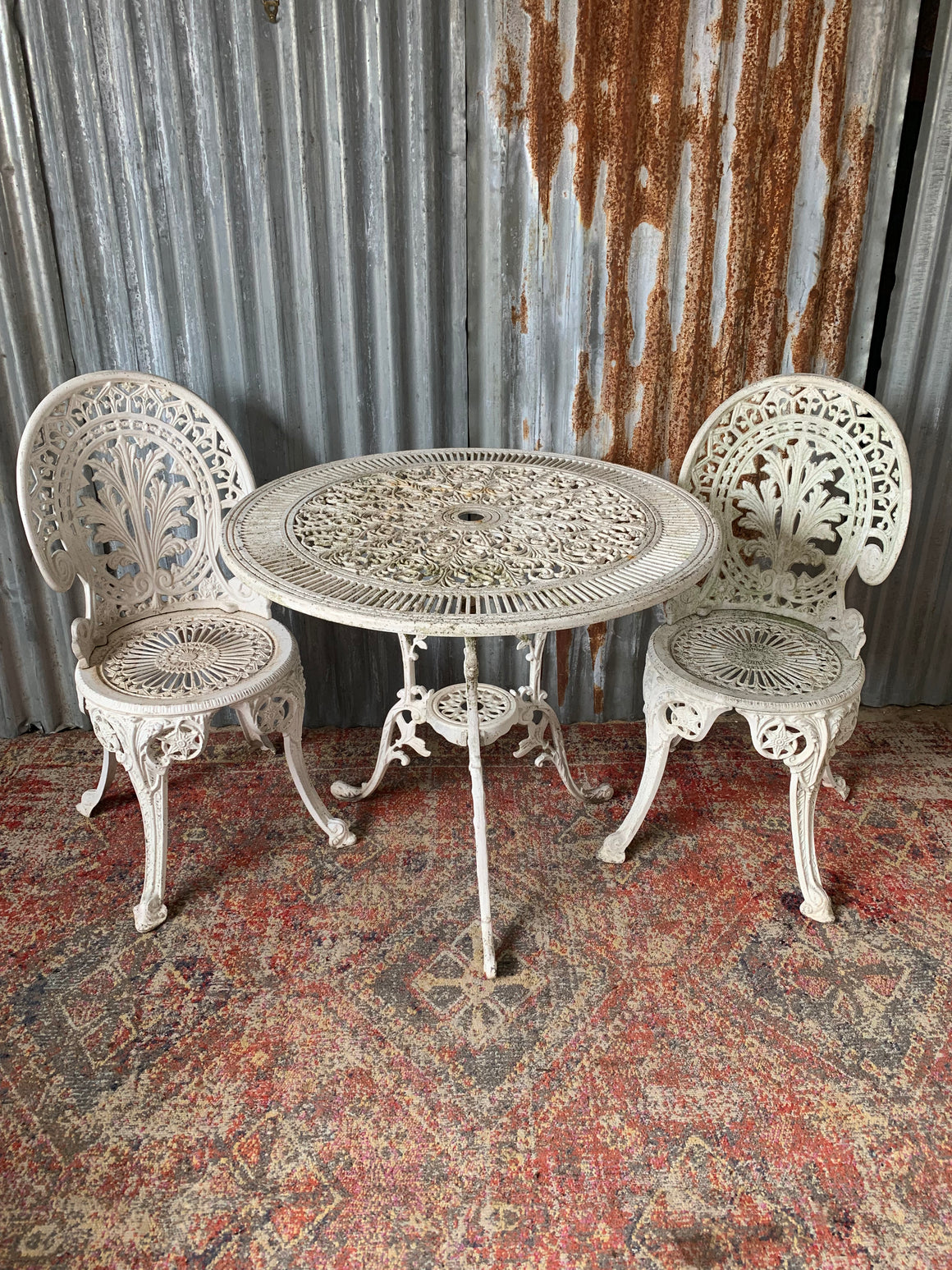 A white Victorian style table and two chairs garden set