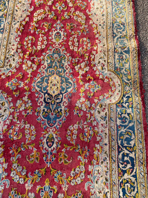 A fuchsia ground Persian rectangular rug