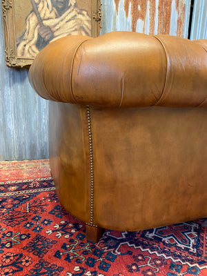A brown Chesterfield armchair with button back and seat