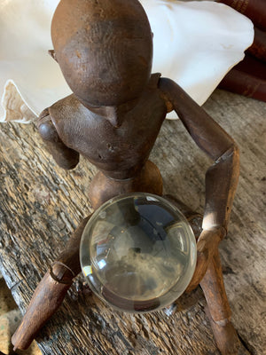 A fortune teller's crystal ball on a silver plated dolphin stand