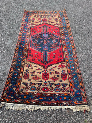 A long hand woven Persian red and blue ground rectangular rug