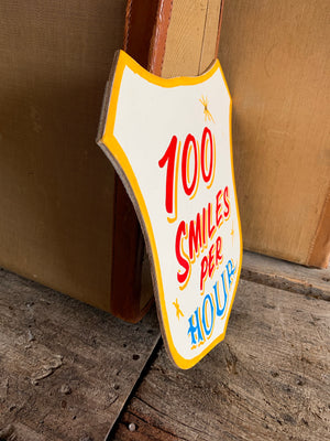 A hand painted fairground advertising sign - 100 Smiles per Hour