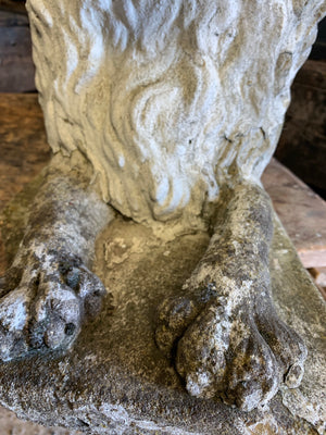 A pair of weathered cast stone recumbent lion statues
