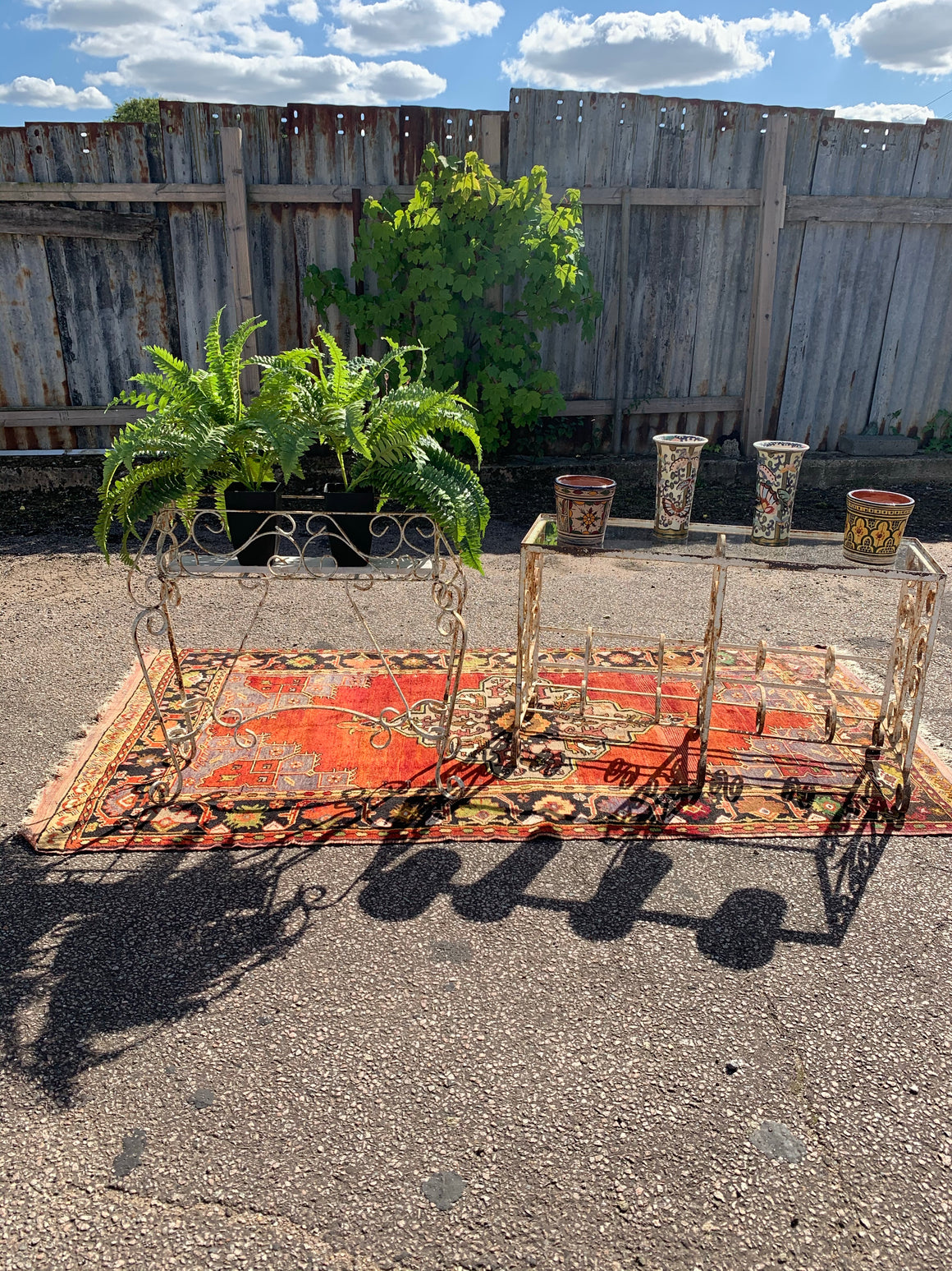 A weathered white wrought iron wirework planter