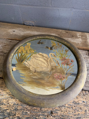 A large hand-painted circular mirror with swans and swallows