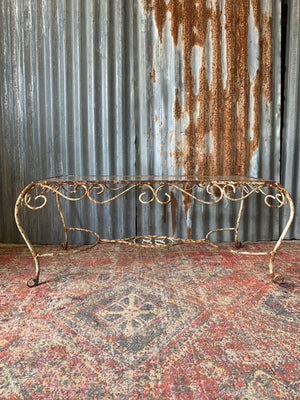 An ornate cast iron table with tempered glass top