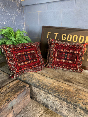 A large pair of red ground Persian carpet cushions