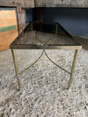 A Hollywood Regency rectangular coffee table with smoked glass