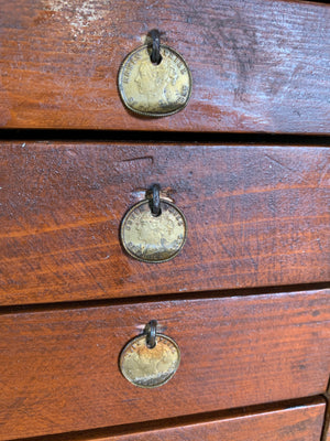 A bank of wooden table top watchmaker's drawers