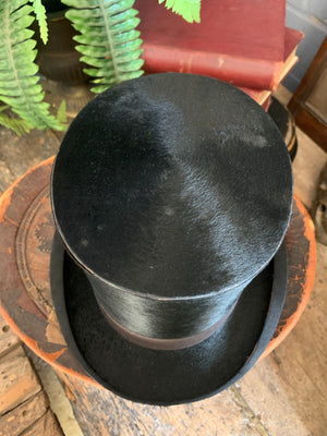 A Victorian black top hat and leather hatbox