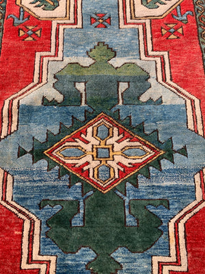 A hand woven Persian red, blue & green ground rectangular rug