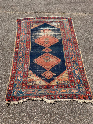 A hand woven Persian red and blue ground large rectangular rug