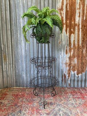 A three-tiered black wire work plant stand