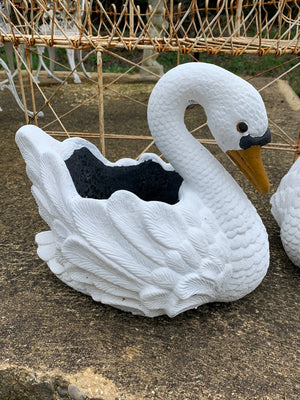 A pair of cast stone planters in the form of swans