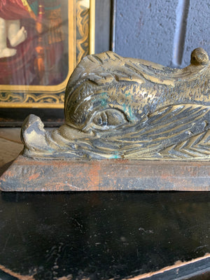A pair of dolphin motif brass and cast iron doorstops