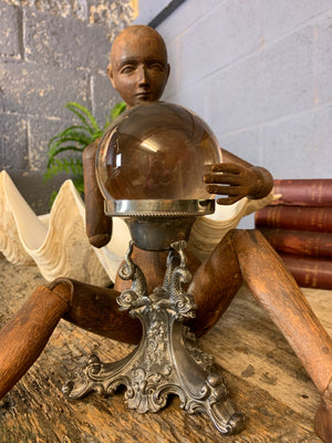 A fortune teller's crystal ball on a silver plated dolphin stand