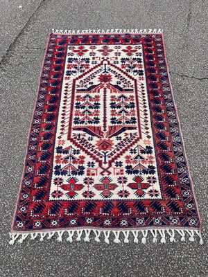 A red and cream ground rug - 195cm x 112cm