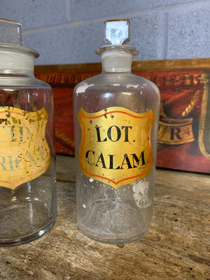 A collection of five hand painted glass apothecary bottles